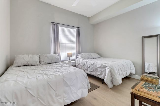 Bedroom with light wood finished floors and a ceiling fan | Image 10