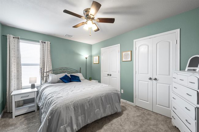 Bedroom with multiple closets, carpet flooring, and ceiling fan | Image 30