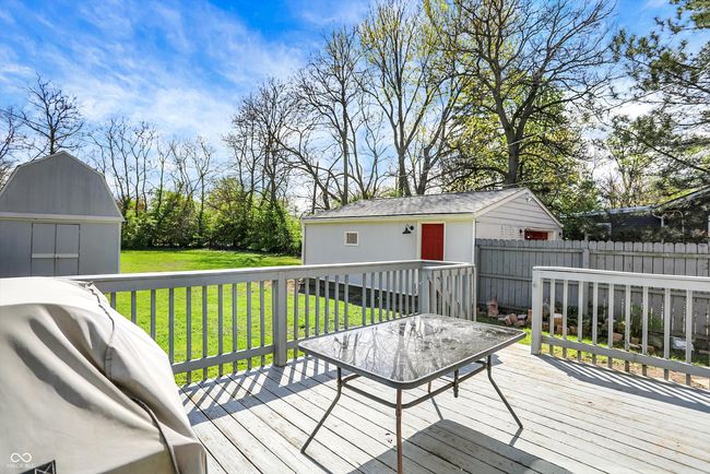 wooden terrace featuring a storage unit, fence, a lawn, an outdoor structure, and area for grilling | Image 38