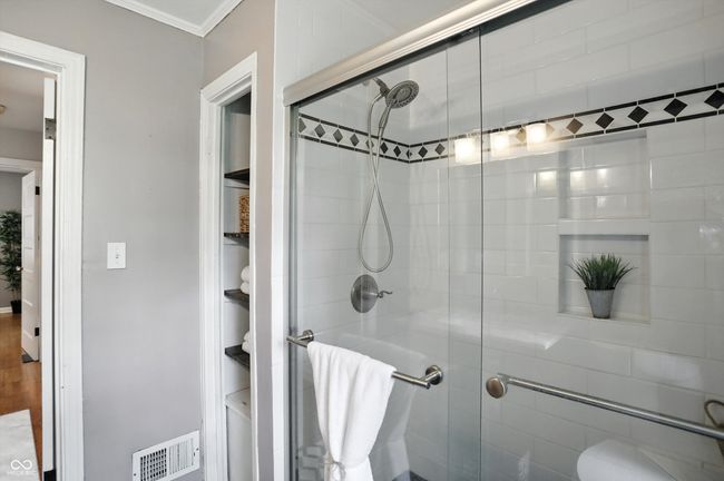 bathroom with a shower stall and ornamental molding | Image 28
