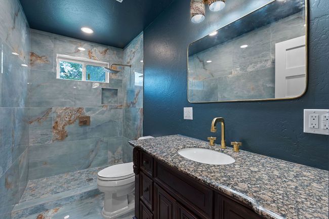 Full bathroom with a textured wall, a tile shower, and vanity | Image 11
