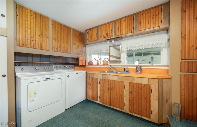 Laundry area with cabinet space, washing machine and clothes dryer, and a sink | Image 23