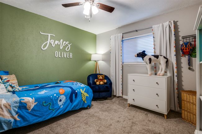 Bedroom with carpet floors, ceiling fan, and a textured wall | Image 18