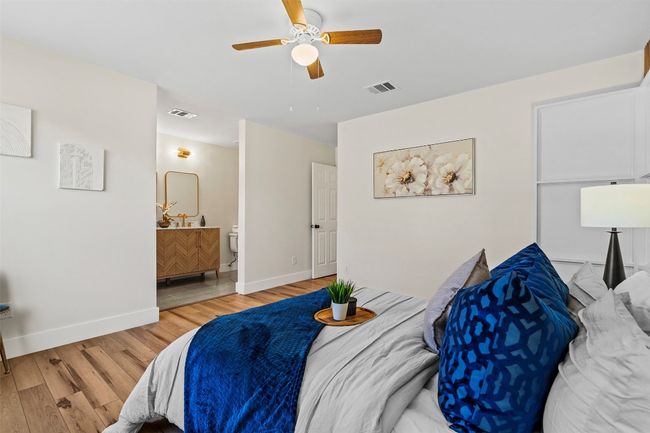 Bedroom with light wood-style flooring, baseboards, ceiling fan, and connected bathroom | Image 22