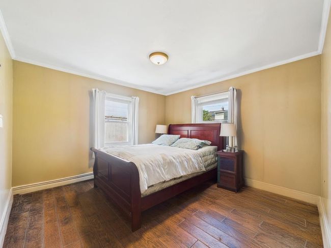 Bedroom featuring hardwood / wood-style floors, crown molding, and a baseboard radiator | Image 20