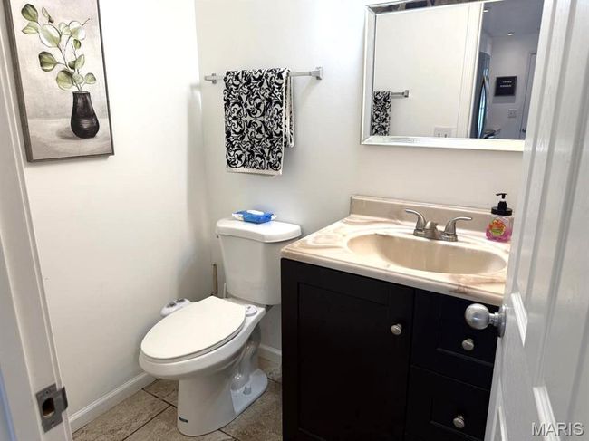 Half bathroom with vanity, tile patterned flooring, baseboards, and toilet | Image 17
