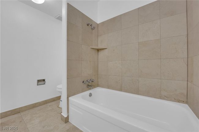 Bathroom featuring toilet, baseboards, shower / tub combination, and tile patterned floors | Image 16