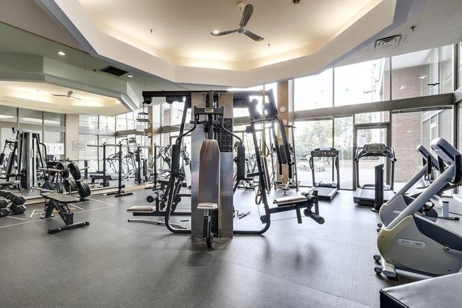 Exercise room featuring visible vents, expansive windows, and a tray ceiling | Image 21