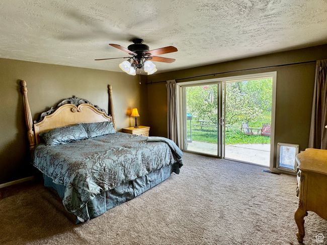 Carpeted bedroom featuring a textured ceiling, visible vents, a ceiling fan, and access to exterior | Image 18