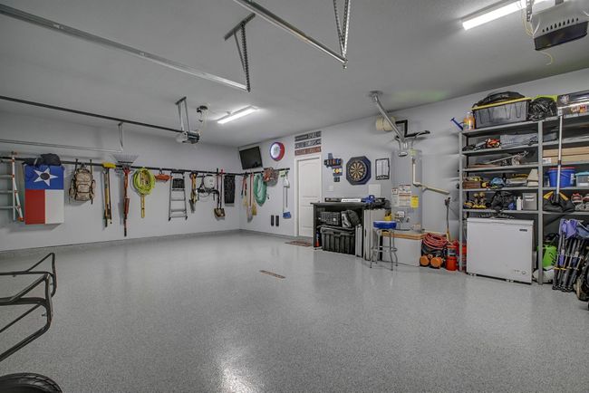 Garage with gas water heater, a garage door opener, and refrigerator | Image 23
