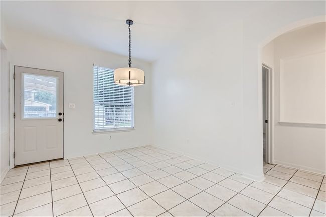 Unfurnished dining area with arched walkways and light tile patterned floors | Image 12