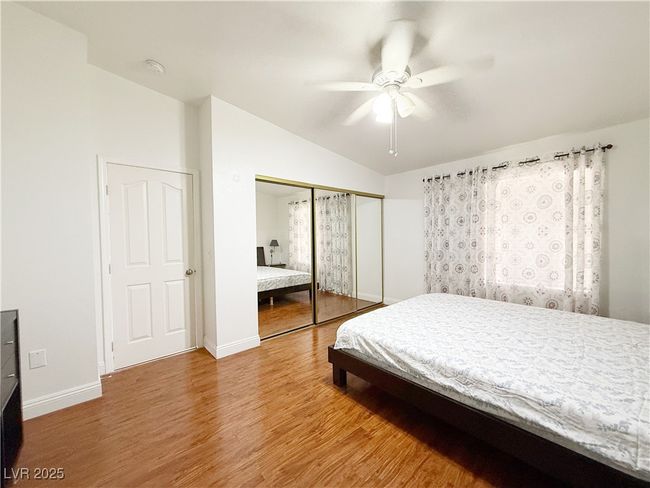 Bedroom with wood finished floors, a closet, ceiling fan, baseboards, and lofted ceiling | Image 32