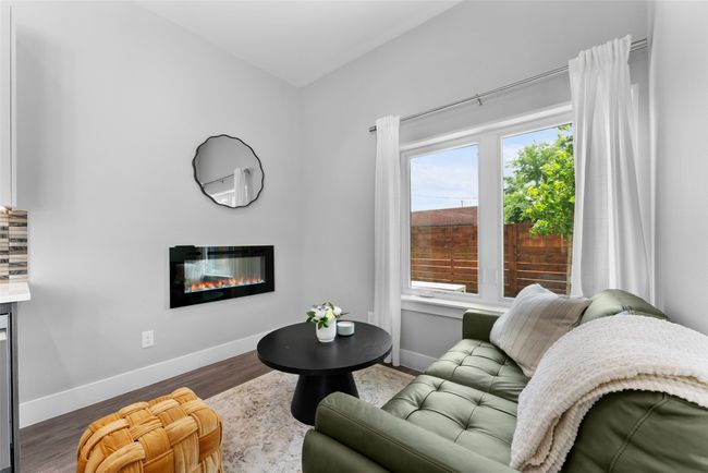 Living room with baseboards, a glass covered fireplace, and wood finished floors | Image 4