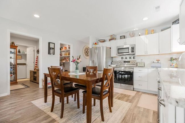 Dining area with light wood finished floors, visible vents, and recessed lighting | Image 9
