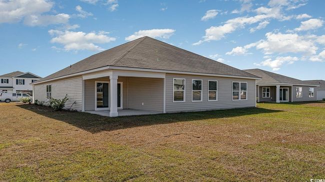 Rear view of house with a patio area and a lawn | Image 4