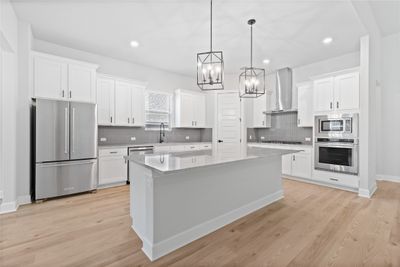 The kitchen comes equipped with upgraded, Kitchen Aid stainless steel appliances, a gorgeous center island, and French-door refrigerator. | Image 3