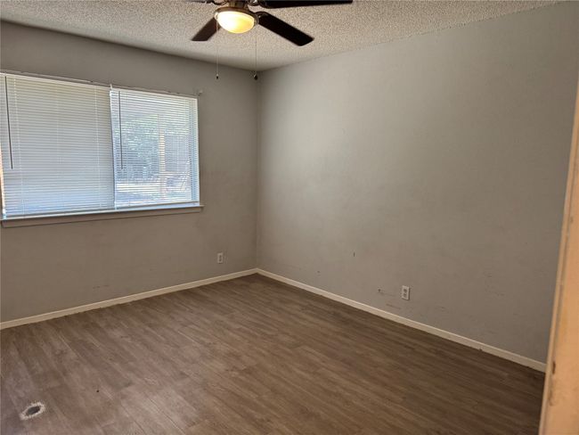 Unfurnished room featuring dark wood finished floors, a textured ceiling, and a ceiling fan | Image 7