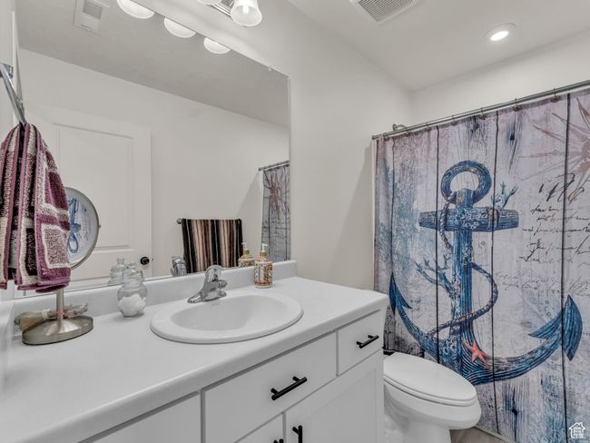 Bathroom with vanity, toilet, curtained shower, and recessed lighting | Image 15