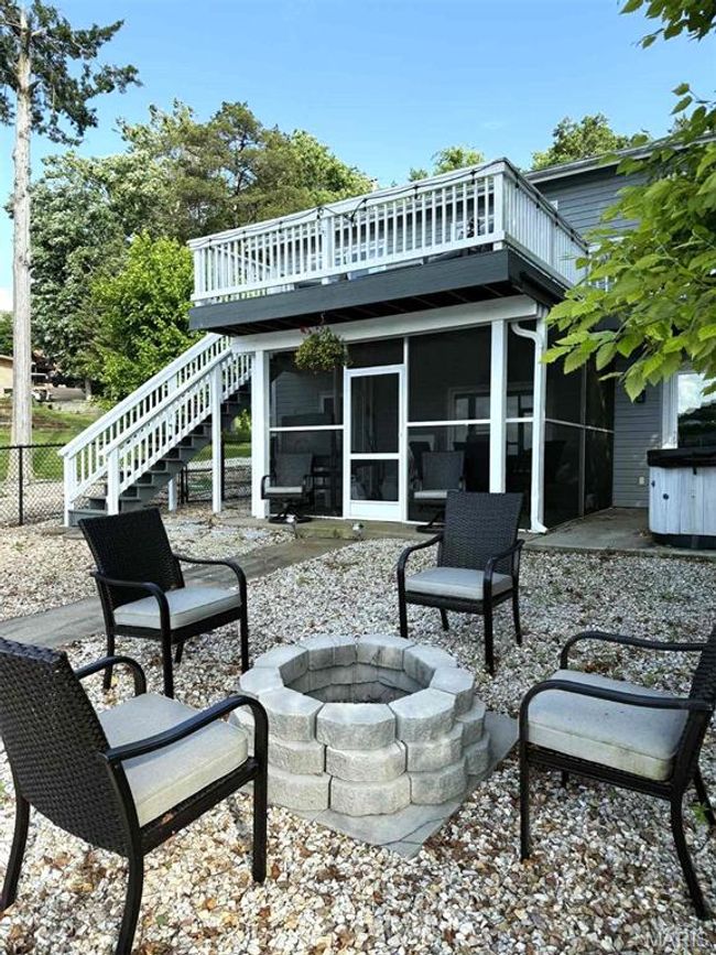 View of patio featuring an outdoor fire pit, a sunroom, stairs, and a wooden deck | Image 31