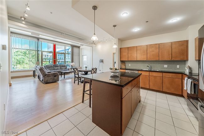 Kitchen with tasteful backsplash, pendant lighting, light tile patterned flooring, open floor plan, and a kitchen island | Image 14