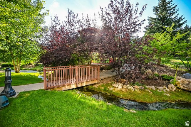 View of property's community featuring a wooden deck and a lawn | Image 42