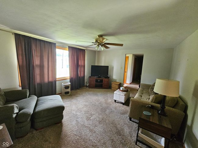 living area with a ceiling fan and light colored carpet | Image 8