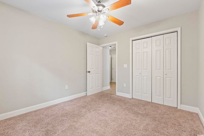 Unfurnished bedroom with carpet, baseboards, a closet, and a ceiling fan | Image 33