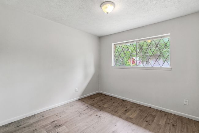 Spare room featuring wood finished floors and a textured ceiling | Image 13