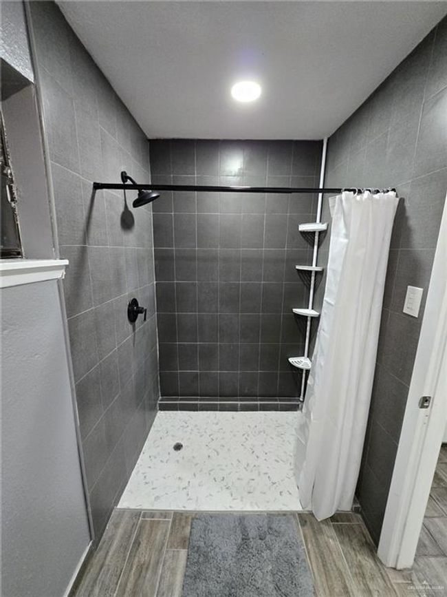 Bathroom featuring wood finished floors and tiled shower | Image 7