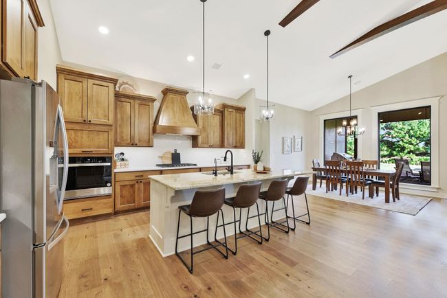 Kitchen with premium range hood, an inviting chandelier, appliances with stainless steel finishes, and a kitchen bar | Image 12