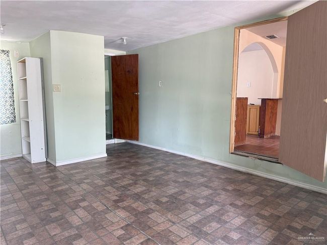 Unfurnished living room with baseboards, brick patterned floor, and visible vents | Image 4