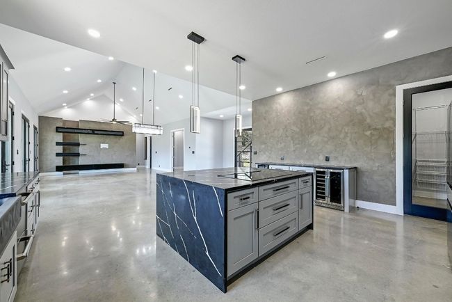 The gorgeous oversized waterfall island offers inviting bar seating that everyone will want to gather around with plenty of space for more than one chef prepping meals at once. | Image 15