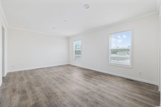 Spare room with wood finished floors and crown molding | Image 23