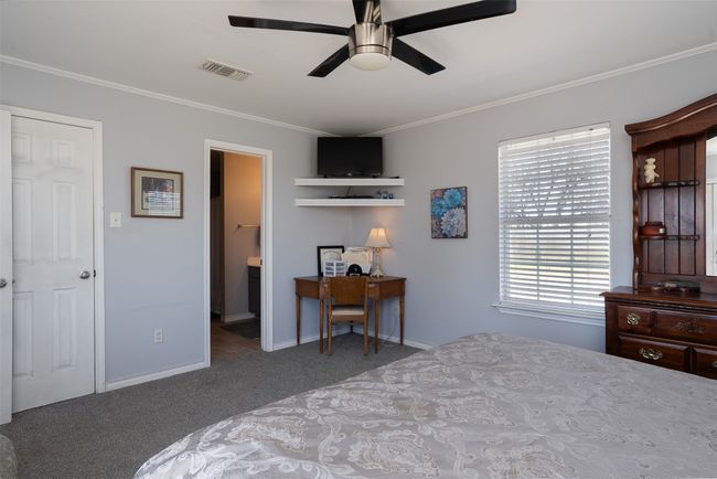 Bedroom featuring carpet, crown molding, an office area, baseboards, and a ceiling fan | Image 17
