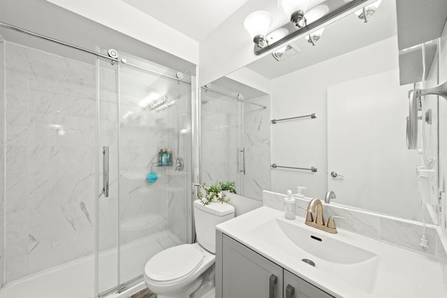 Bathroom with a marble finish shower, toilet, and vanity | Image 22