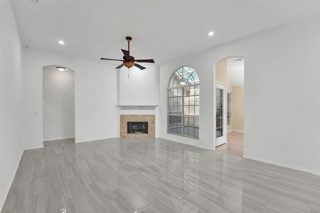 Unfurnished living room featuring ceiling fan and a fireplace | Image 12