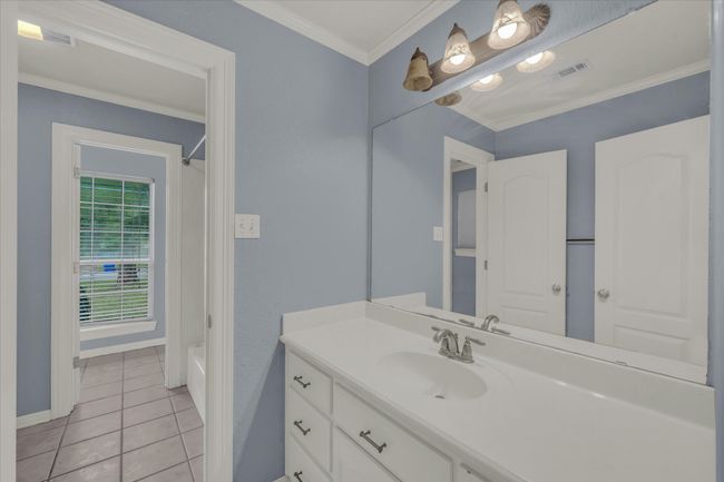Full bath with vanity, tile patterned flooring, shower / bath combo, and crown molding | Image 30