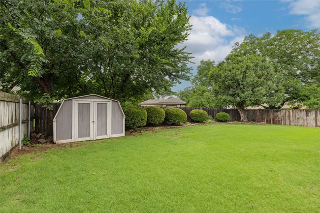 Fenced backyard with a storage unit | Image 32