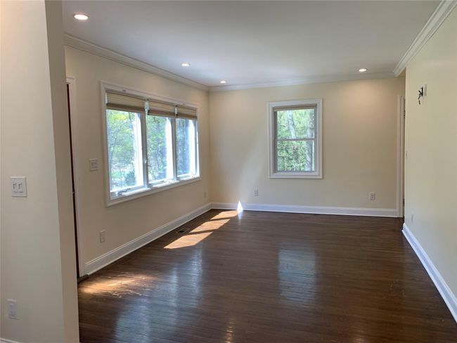 Empty room with a wealth of natural light, crown molding, and dark wood-type flooring | Image 4