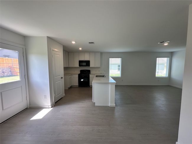Kitchen featuring plenty of natural light, black appliances, light countertops, open floor plan, and recessed lighting | Image 4