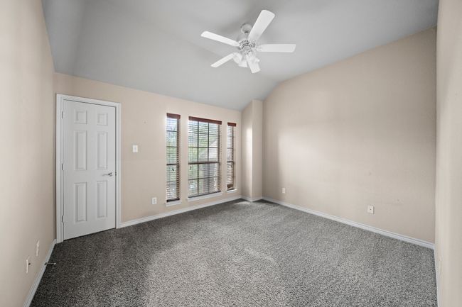 Carpeted spare room with a ceiling fan, baseboards, and lofted ceiling | Image 32