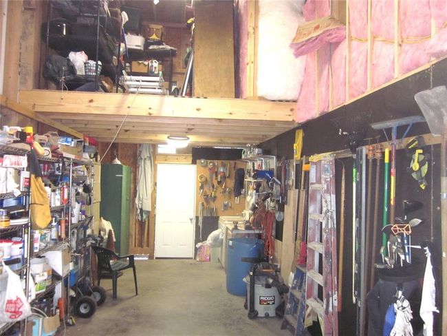 Discover a versatile 2-story workshop next to the guest suite, featuring abundant storage with a 10x25 ft area below and an 8x12 ft space above. Includes a garage door, garden access, and a to a separate storage building. Flexible mobile home/boot storage or 1 car garage conversion. | Image 39