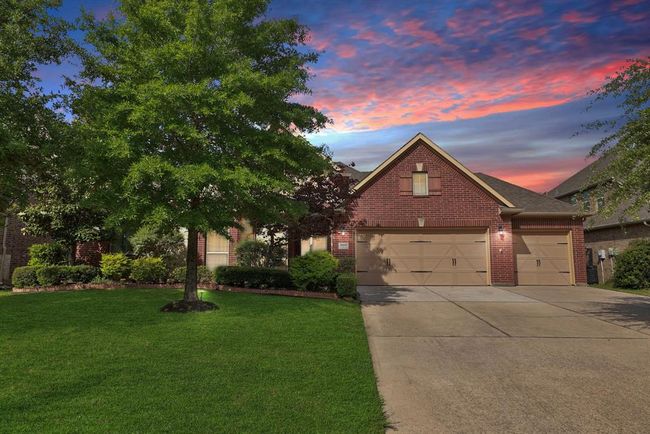 Elongated driveway to 3 car front load garage with side door to backyard making maintenance days easy. | Image 5