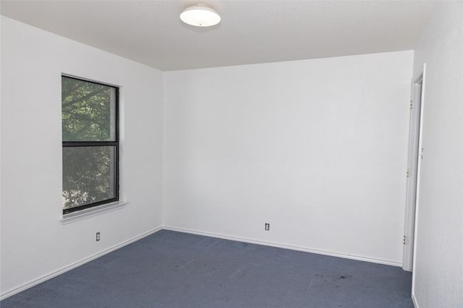 Empty room featuring dark colored carpet and baseboards | Image 12