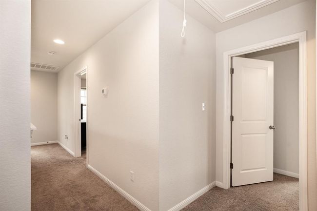 Hallway with carpet flooring and baseboards | Image 25