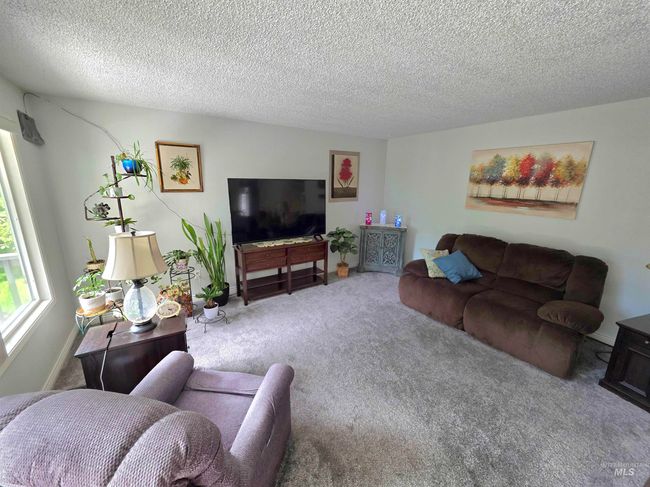 Carpeted living area with a textured ceiling | Image 8