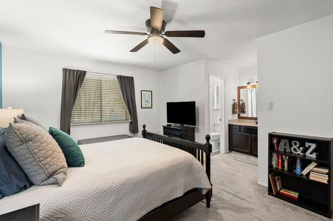 Bedroom featuring light carpet, connected bathroom, and ceiling fan | Image 17