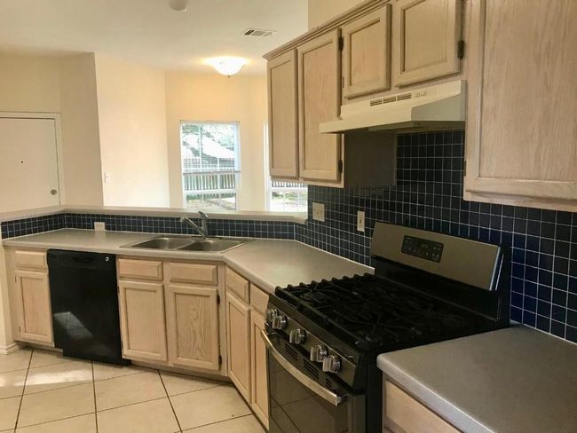 Kitchen featuring dishwasher, stainless steel range with gas cooktop, under cabinet range hood, and light brown cabinetry | Image 6