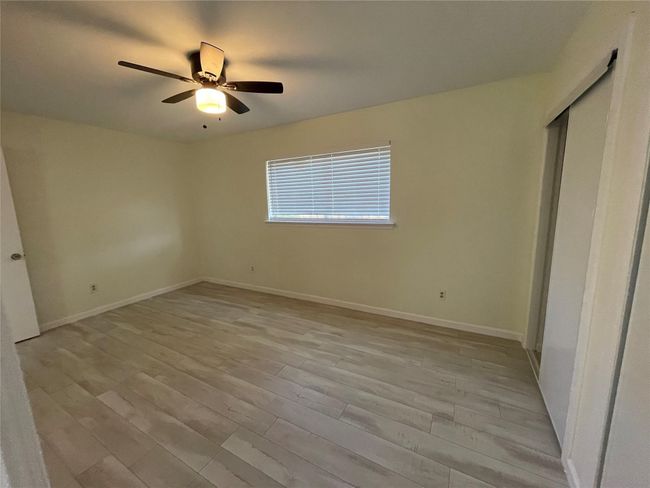 Unfurnished bedroom with baseboards, light wood-type flooring, ceiling fan, and a closet | Image 13