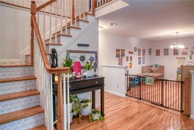 Stairs featuring a notable chandelier and light hardwood / wood-style flooring | Image 3